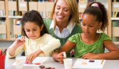 faculty staff assisting children in an activity